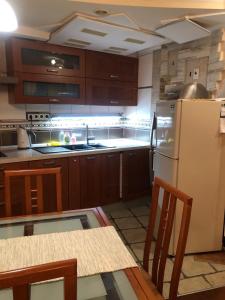 cocina con armarios de madera y nevera blanca en Apartaments Teris en Zhytomyr