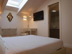 a bedroom with a large white bed and a window at Acquaderni Rooms in Bologna