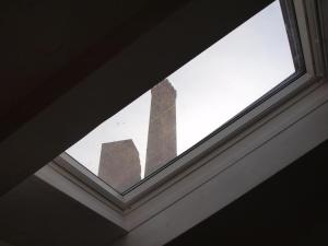 a window in a building with a monument in the background at Acquaderni Rooms in Bologna