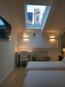 a bedroom with a bed and a window and a table at Acquaderni Rooms in Bologna