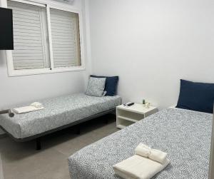 a small room with two beds and a window at Precioso apartamento con piscina a 50m de la playa in Candelaria