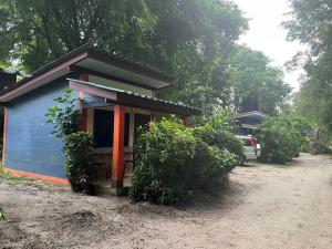 Garden Bungalow Resort في Thai Muang: منزل أزرق صغير مع سيارة متوقفة بجواره