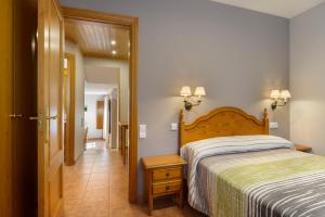 a bedroom with a bed and a hallway at Apartamentos Casa Aurelia in Alquézar