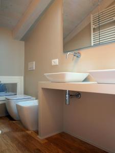 a bathroom with two sinks and a toilet at Acquaderni Rooms in Bologna