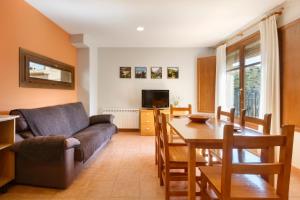 una sala de estar con un sofá y una mesa en Apartamentos Casa Aurelia, en Alquézar