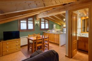 Una cocina con una mesa y un comedor. en Apartamentos Casa Aurelia, en Alquézar