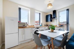 een keuken en eetkamer met een witte tafel en stoelen bij SPECIAL OFFER!! Wednesbury, 1& 2 Bedroom Apartments with Private Parking by 12Stay in Wednesbury