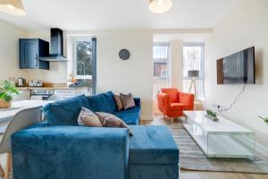 a living room with a blue couch and an orange chair at SPECIAL OFFER!! Wednesbury, 1& 2 Bedroom Apartments with Private Parking by 12Stay in Wednesbury