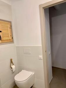 a bathroom with a toilet and a toilet paper dispenser at Cal Torrentó Apartaments in Balaguer