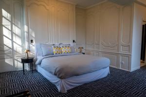 una camera con un grande letto di Les Suites Château du Breuil Normandie a Le Breuil-en-Auge