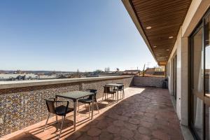 a patio with tables and chairs on a roof at Hotel Moinho De Vento in Viseu