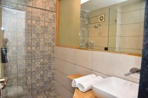 a bathroom with a sink and a mirror at Caravan Baga Aqua Resort in Baga