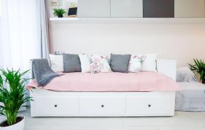 ein weißes Bett mit Kissen auf dem Zimmer in der Unterkunft Silver Lodge Ezüstpart Apartman in Siófok