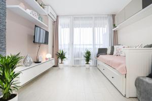 sala de estar con cama y TV en Silver Lodge Ezüstpart Apartman en Siófok