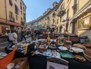 a market in a street with tables filled with food at Borgo Dora House in Turin