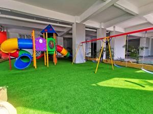 a playground with colorful playground equipment on the grass at Travelers HomestySitiawan b-30-6 The Venus Aparment in Seri Manjung