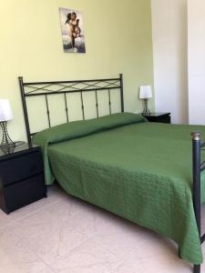 シャッカにあるAppartamento Maranto via Slovenia 12のベッドルーム1室(緑色のベッド1台、ランプ2つ付)