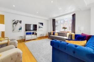 sala de estar con sofá azul y TV en The Princes Residences en Londres