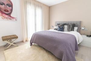un dormitorio con una cama y una pintura de una mujer en Villa La Sala Puerto Banus, en Marbella