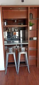 una cucina con bancone e 2 sgabelli di En el Corazón del Barrio Providencia, tranquilo y confortable departamento a Santiago