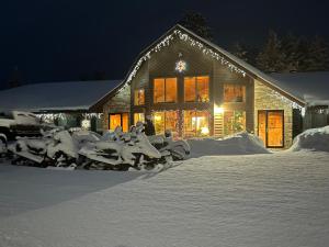uma casa coberta de neve à noite com luzes em Boulder Bear Motor Lodge em Boulder Junction