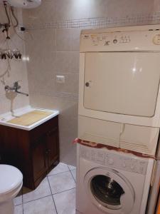 een wasmachine in een badkamer met een wastafel bij SWEET HOME- AMPIO BIVANO A 10 MINUTI DALLE SPIAGGE in Quartu SantʼElena