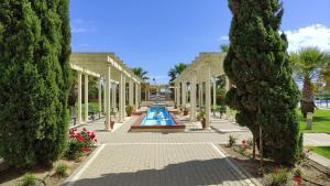 a garden with a swimming pool between two trees at Apartamento Los Pelícanos in Isla Canela
