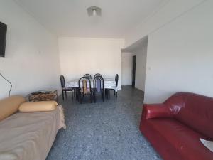 sala de estar con sofá, mesa y sillas en Magnifico departamento frente al casino en Mar del Plata