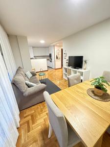 uma sala de estar com uma mesa e um sofá em Apartamento Oviedo Parque del Oeste em Oviedo