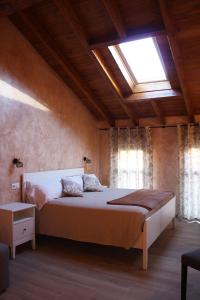 sypialnia z dużym łóżkiem i oknem dachowym w obiekcie CASA PEQUE w mieście Laguardia