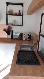 a kitchen counter with a sink and a microwave at Les Réserves du Beffroi in Aire-sur-la-Lys