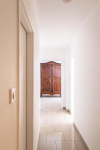 an empty corridor with a wooden cabinet in a room at Appartement Mozart in Strasbourg