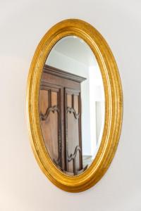 a gold mirror on a wall with a wooden door at Appartement Mozart in Strasbourg