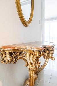 a gold console table with a mirror on the wall at Appartement Mozart in Strasbourg