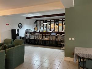 uma sala de espera com cadeiras e um balcão num restaurante em Hotel Ilha em Angra do Heroísmo