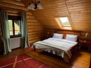 a bedroom with a bed in a log cabin at Chalet 33 - Spacious, cosy and a wonderful view in Predeluţ