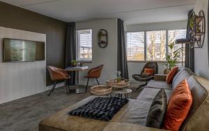 sala de estar con sofá y mesa en Hotel Kogerstaete Texel, en De Koog