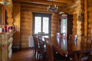 a dining room with a wooden table and chairs at Cabana 33 in Predeluţ +6 photos