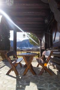 a picnic table and two chairs on a patio at Chalet 33 - Spacious, cosy and a wonderful view in Predeluţ