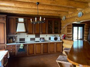 a kitchen with wooden cabinets and a table in a cabin at Chalet 33 - Spacious, cosy and a wonderful view in Predeluţ