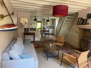 a living room with a white couch and a table at Chez Trudi Charmante maison à la campagne in Livry