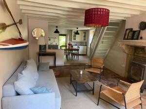 ein Wohnzimmer mit einem weißen Sofa und einem Tisch in der Unterkunft Chez Trudi Charmante maison à la campagne in Livry