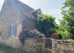 an old house with flowers on the side of it at Chez Trudi Charmante maison à la campagne in Livry