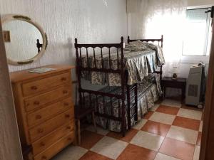 een slaapkamer met een bed, een dressoir en een spiegel bij Two Bed in the Manga in La Manga del Mar Menor