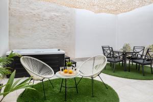 patio z krzesłami i stołem z pomarańczami w obiekcie Lola 14 Suite Apartment w Sewilli