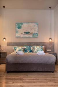 a bedroom with a bed with a painting on the wall at Wisdom Residence Luxury Apartments at Plaka in Athens