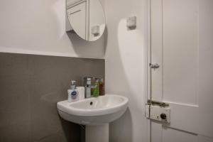 a white bathroom with a sink and a mirror at * Parking * Smart TV * Sleeps up to 7 * Fast Wi-FI in Lincolnshire