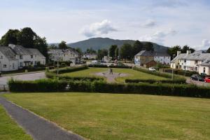 a person riding a bike on a road in a village at Traditional 3 bed town house in Inverlochy