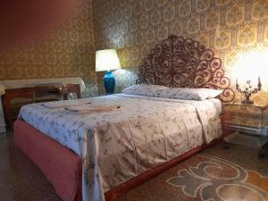 um quarto com uma cama grande e uma grande cabeceira. em Le Stanze del Notaio em Gênova