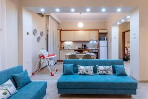 a living room with a blue couch and a kitchen at Anna's House in Komotini